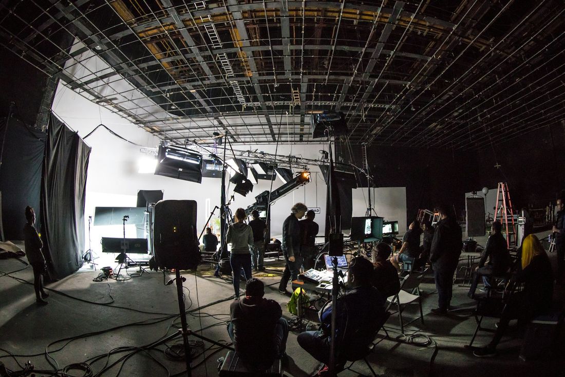 Equipo de rodaje trabajando en un estudio con luces y cámaras